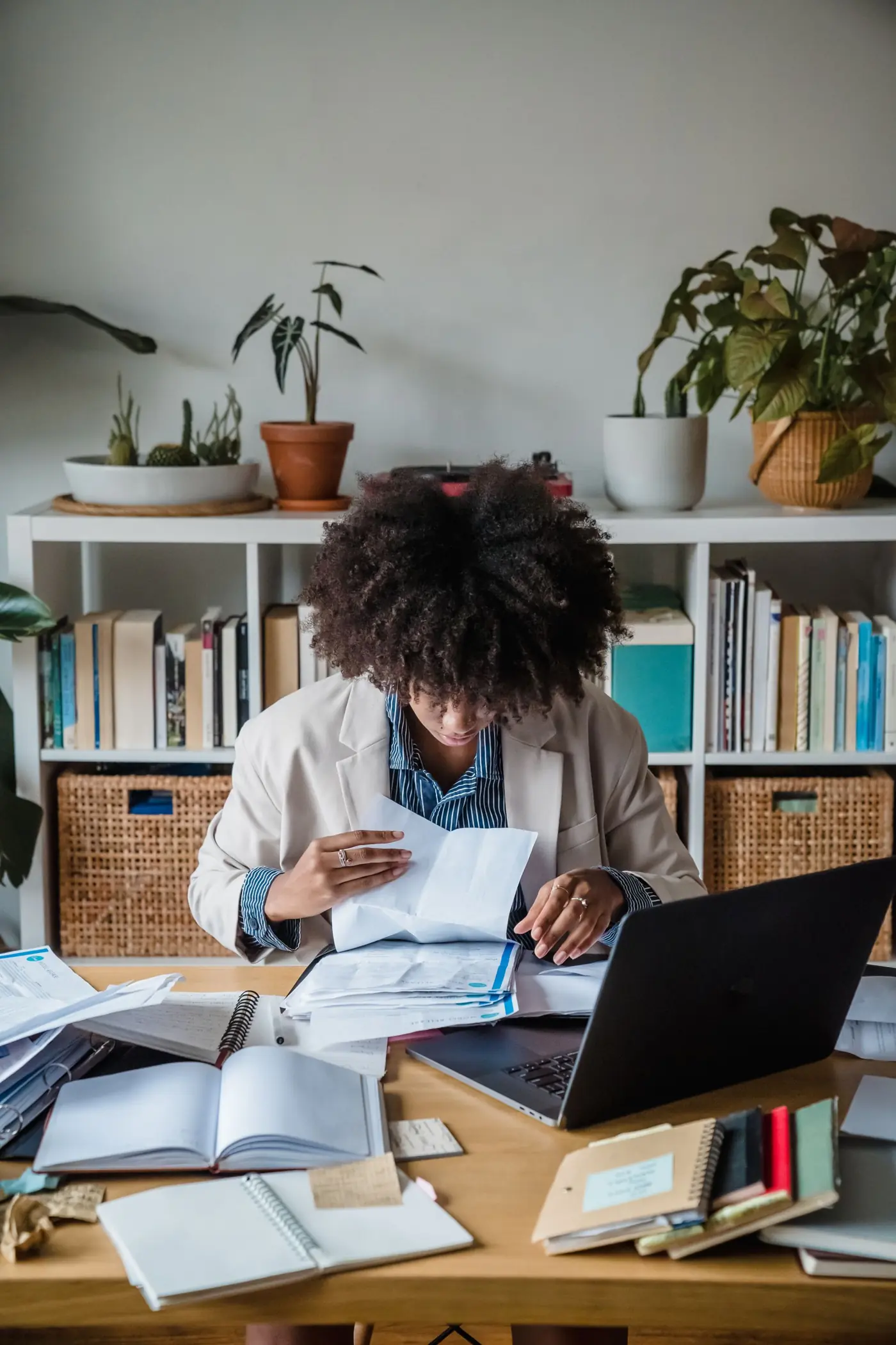 Self-employed woman working through paperwork at her desk at home