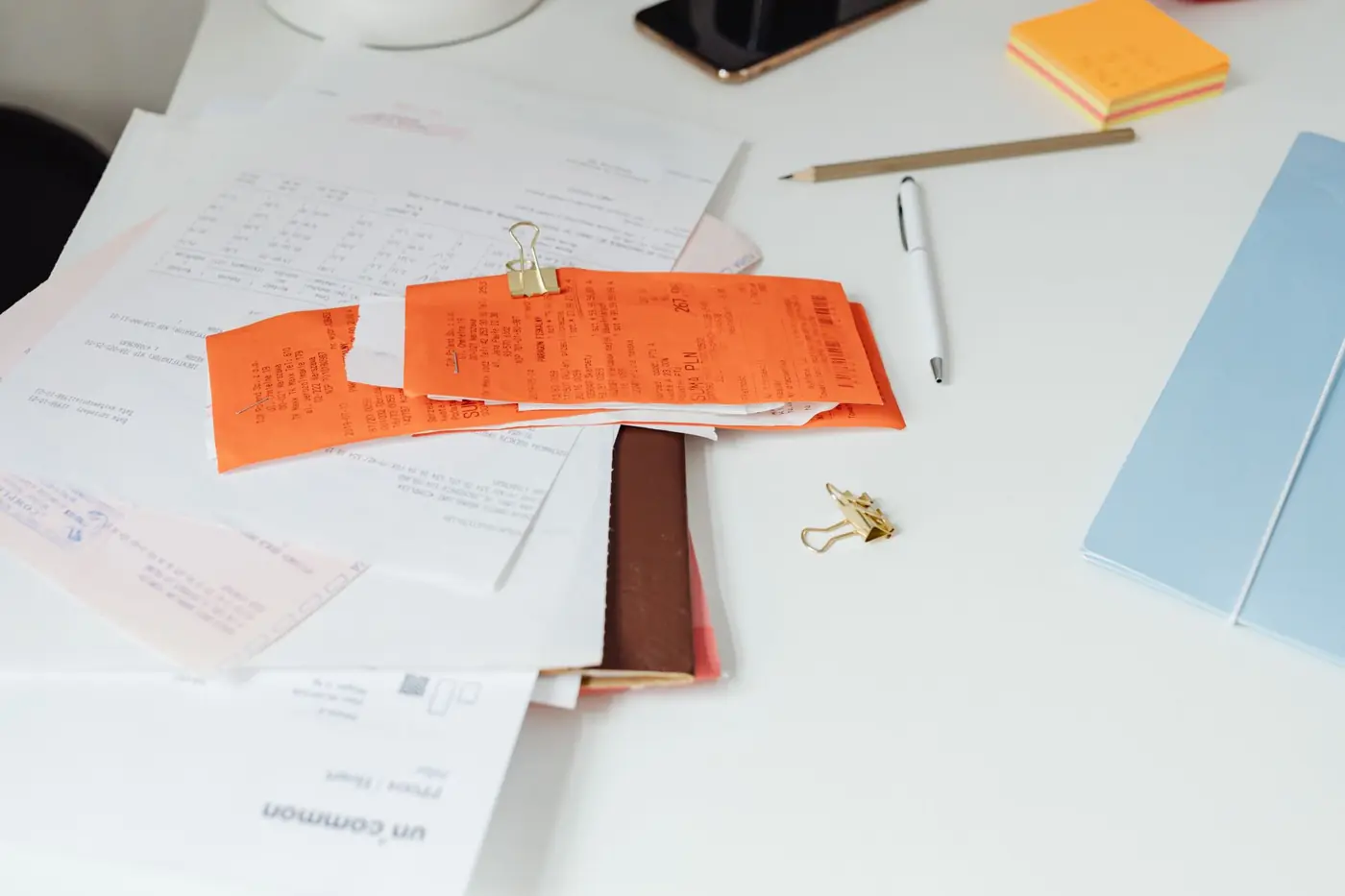 Receipts, invoices and documents spread across a desk ready for a tax return