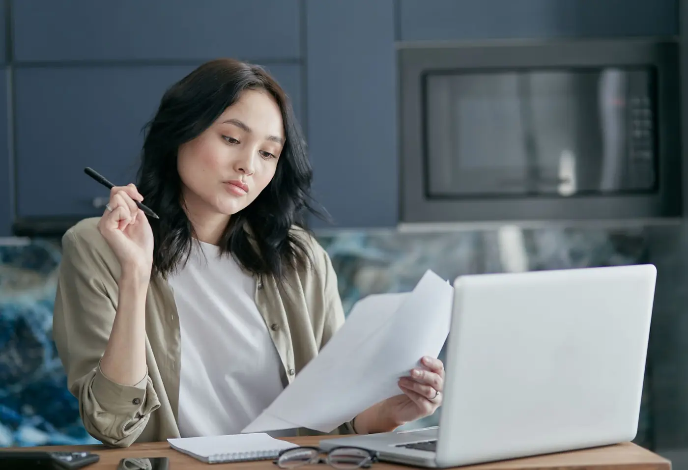 Self-employed woman reviewing documents beside her laptop