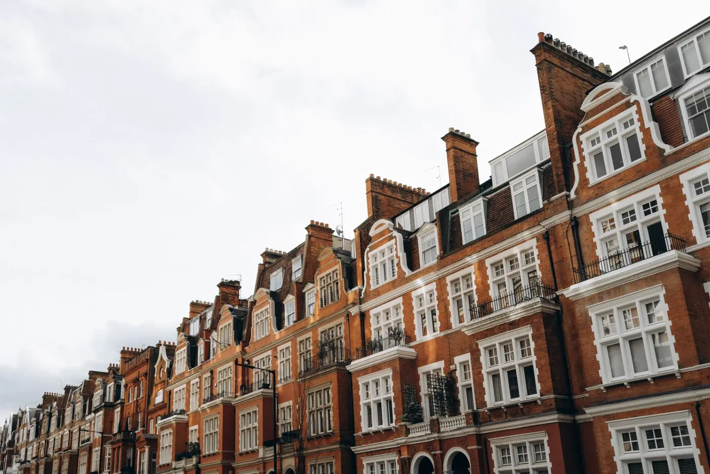 Row of red-brick terraced houses on a British street